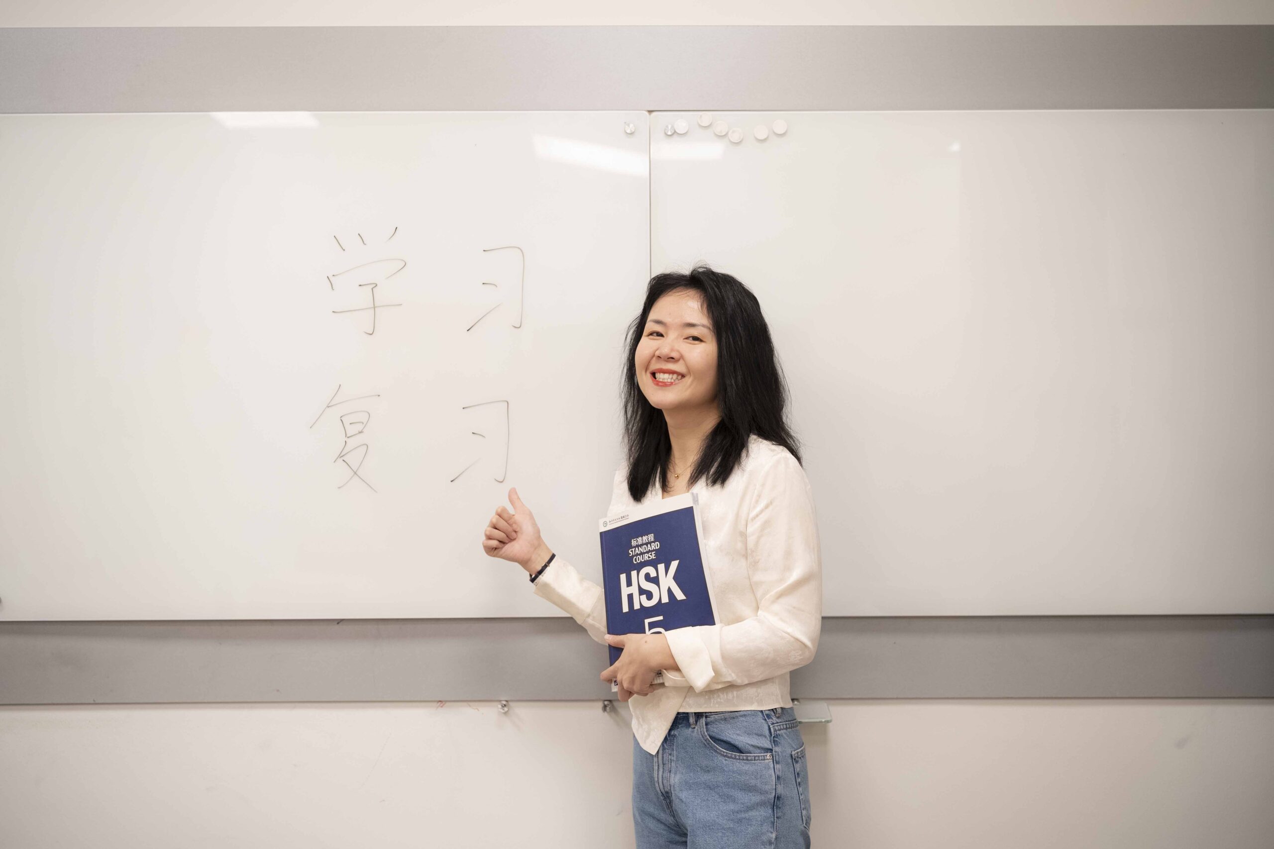 20251211-profesora-de-chino-Pei-Ziyi-dando-clase-con-libro-HSK5-4-web